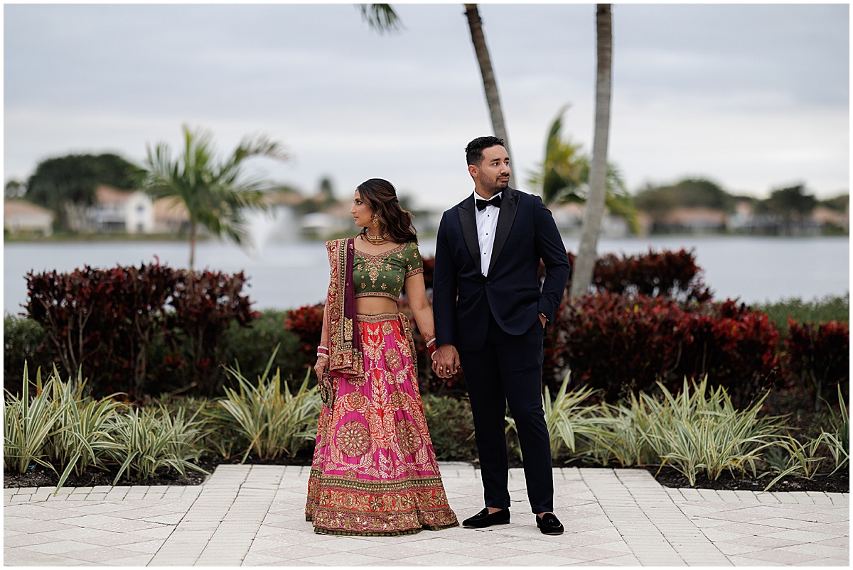 Couple in Indian wedding attire holding hands at their Palm Beach wedding