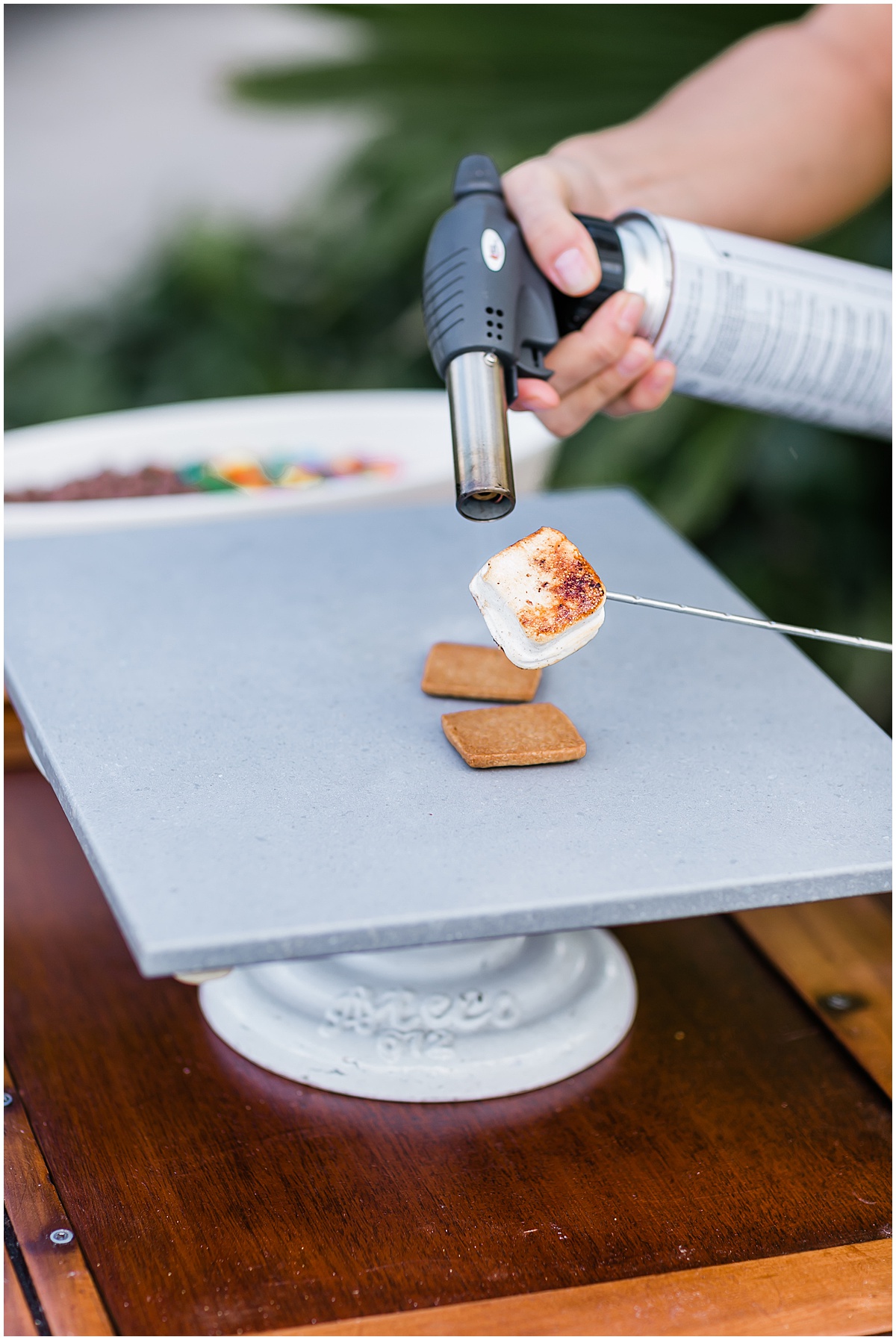Marshmallow being toasted with a torch at a Palm Beach wedding s’mores station