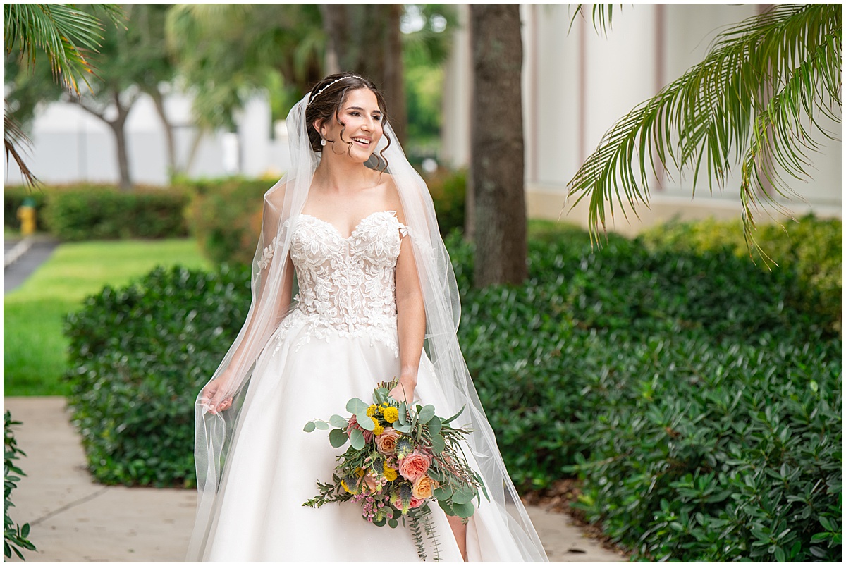 Bride at a Palm Beach wedding venue holding a colorful bouquet