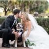 Bride and groom kiss with their dog dressed in a tuxedo at their Palm Beach wedding