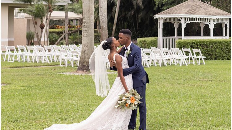 Bride and groom kissing after their outdoor Palm Beach wedding ceremony.