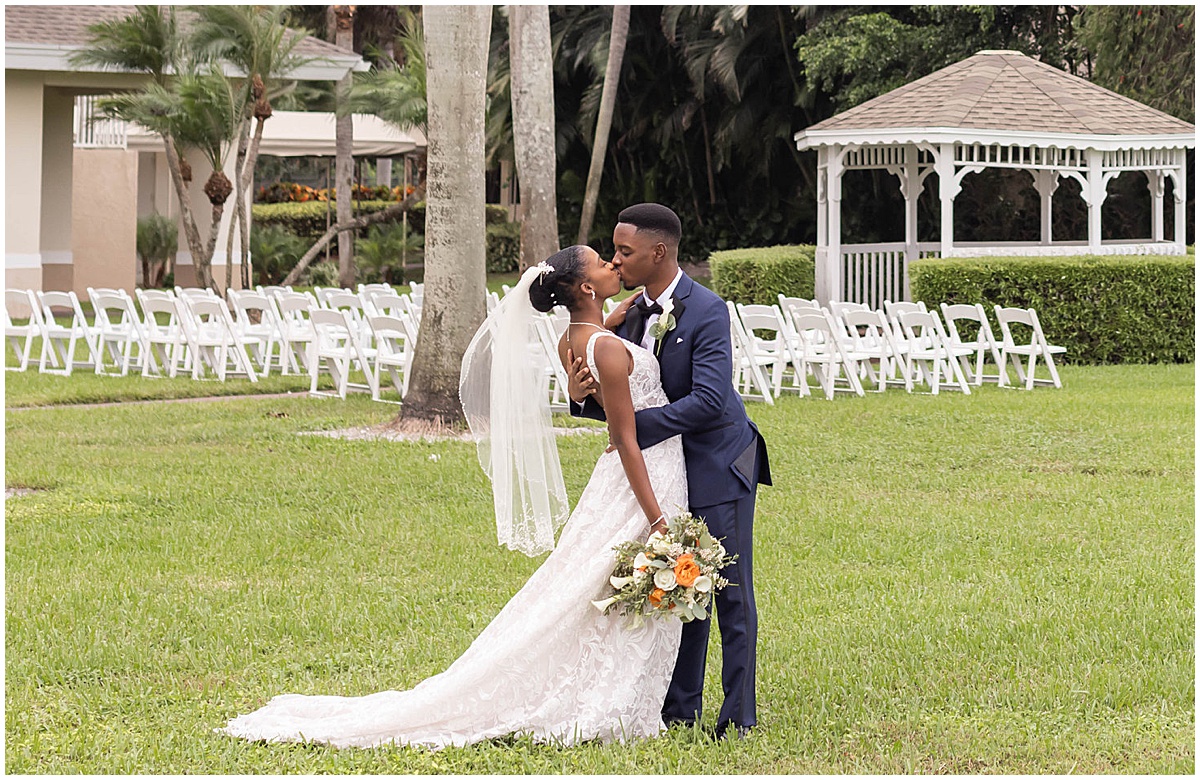 Bride and groom kissing after their outdoor Palm Beach wedding ceremony.