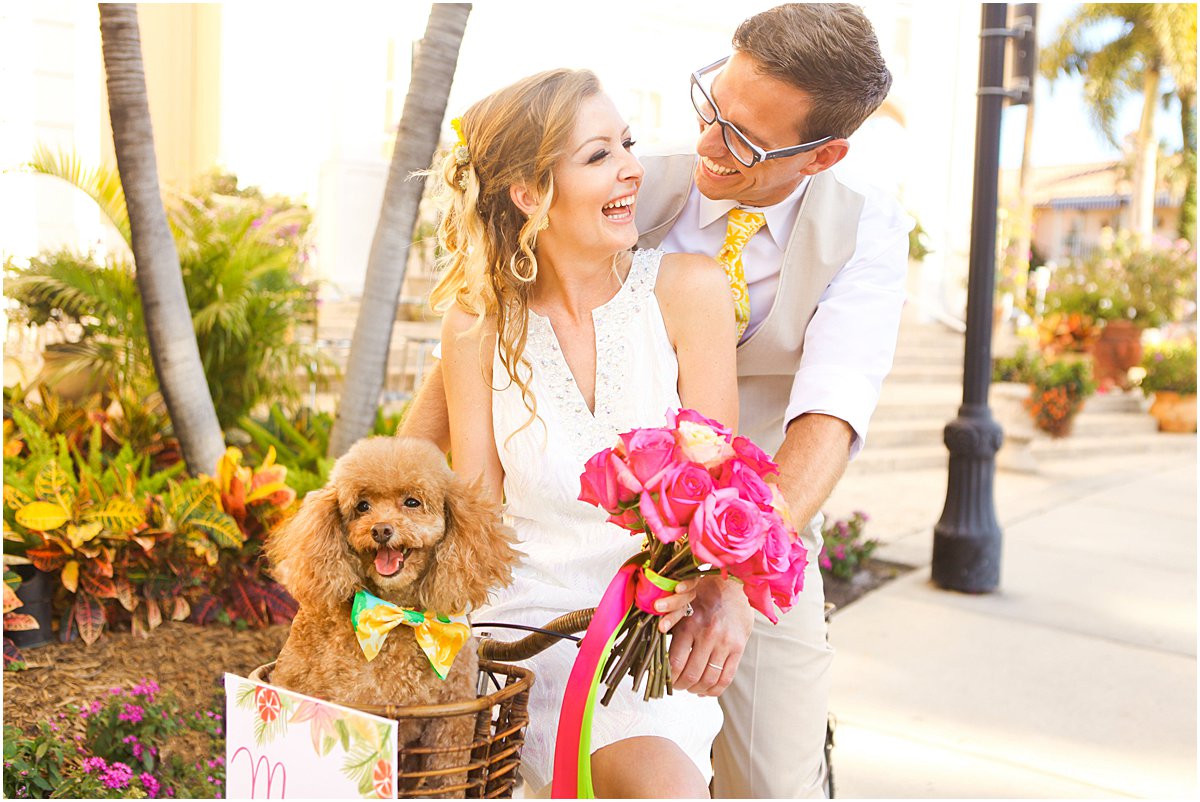 Bride and groom celebrate with their dog in a bicycle basket after their Palm Beach wedding