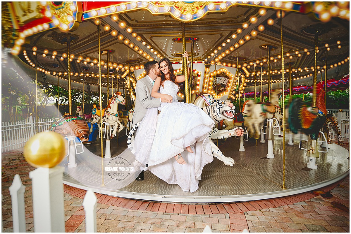 Bride and groom sharing a playful moment on a carousel at their Palm Beach wedding.