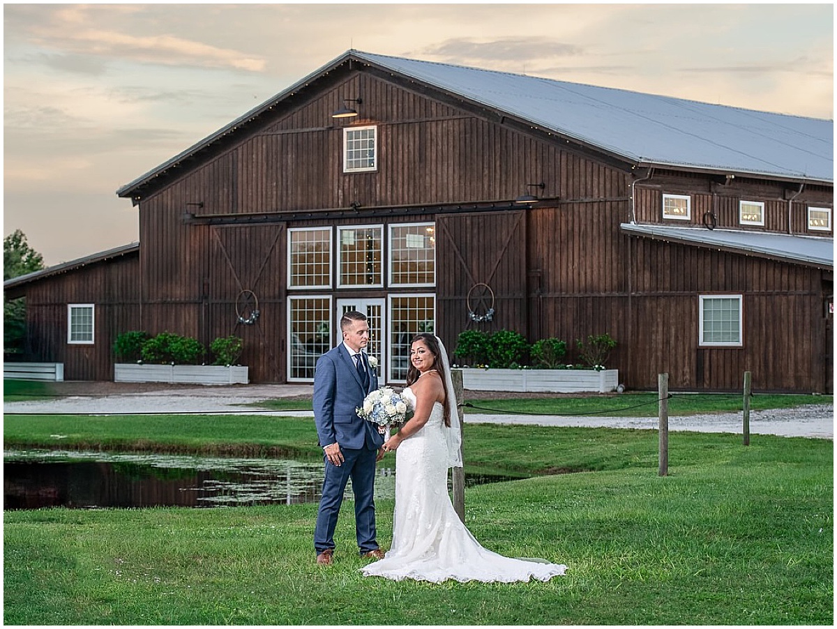 Bride and groom posing outside a rustic barn wedding venue in Palm Beach County.
