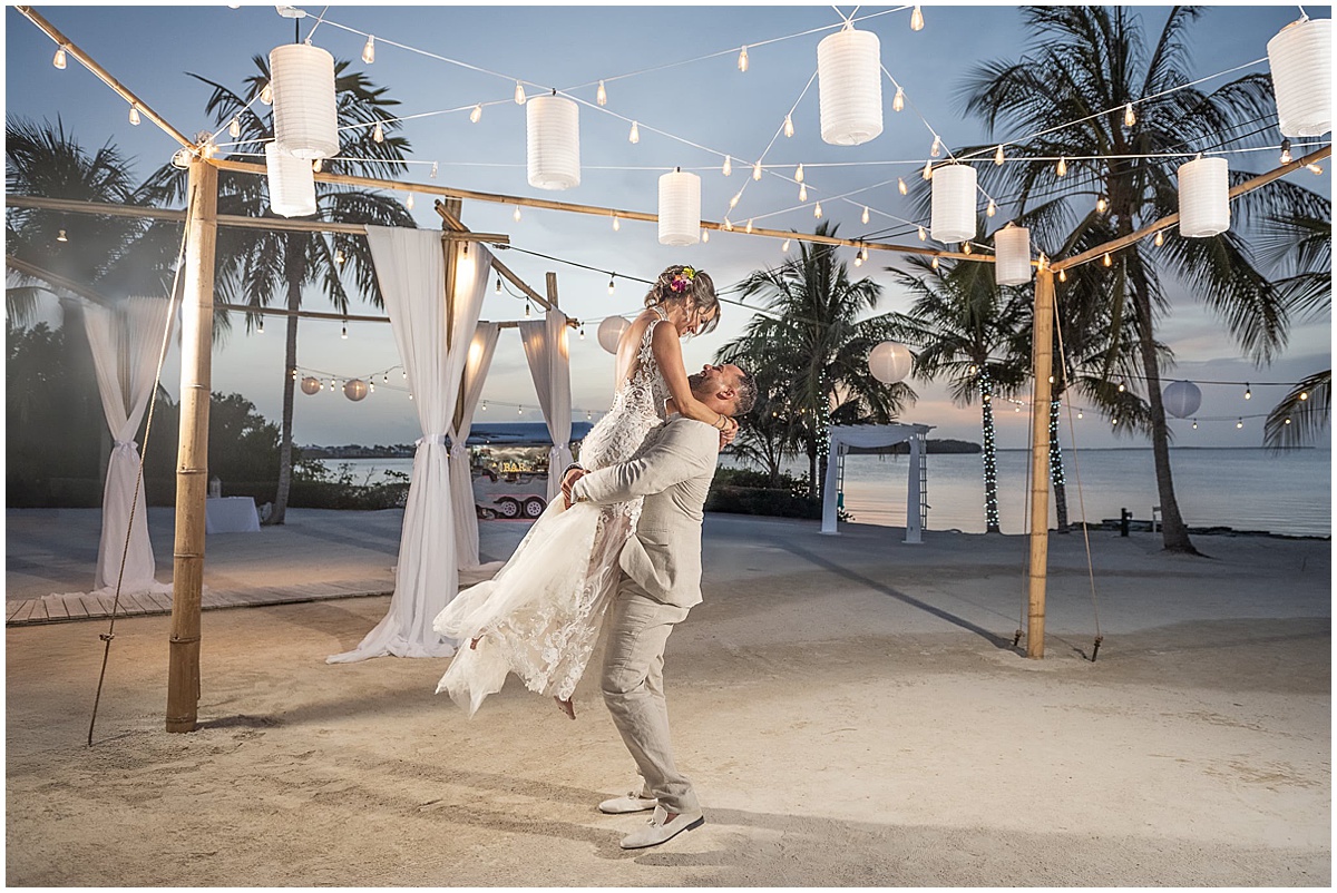 Bride and groom celebrating at a waterfront Palm Beach wedding reception at sunset.