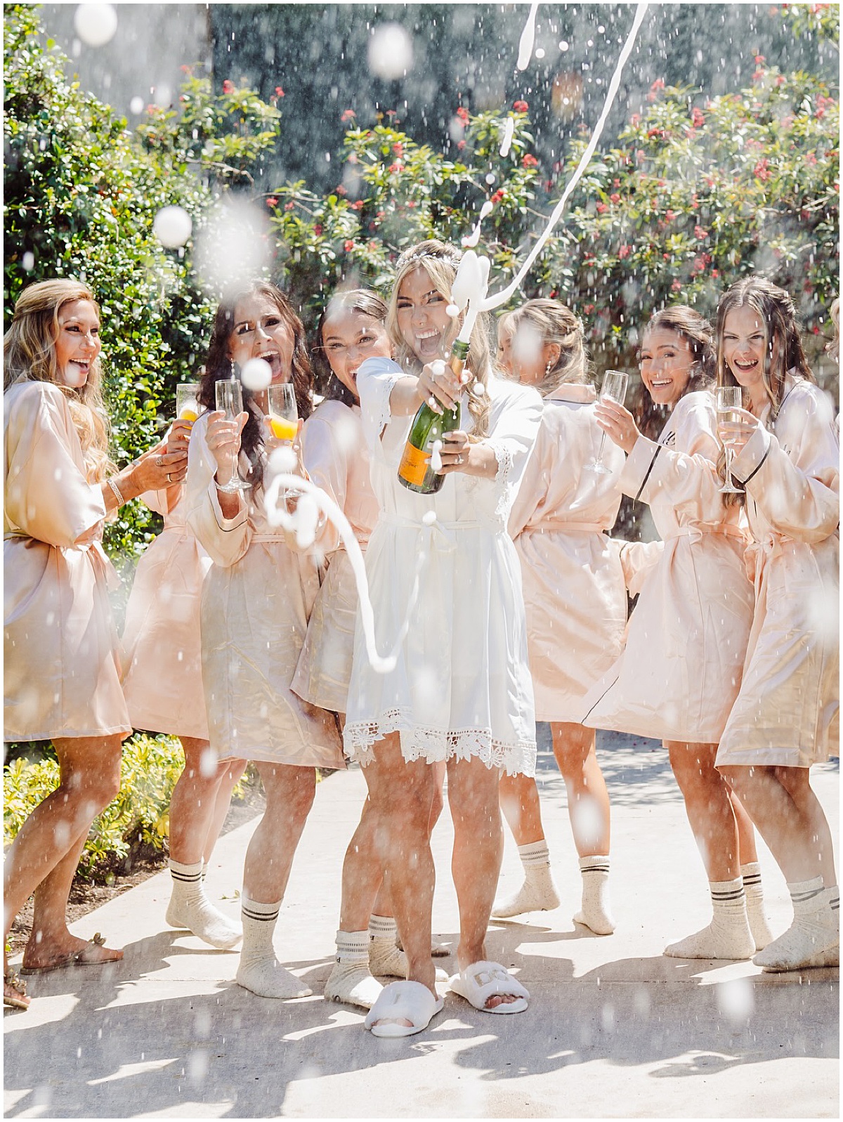 Bride and bridesmaids popping champagne while getting ready for a Palm Beach wedding.