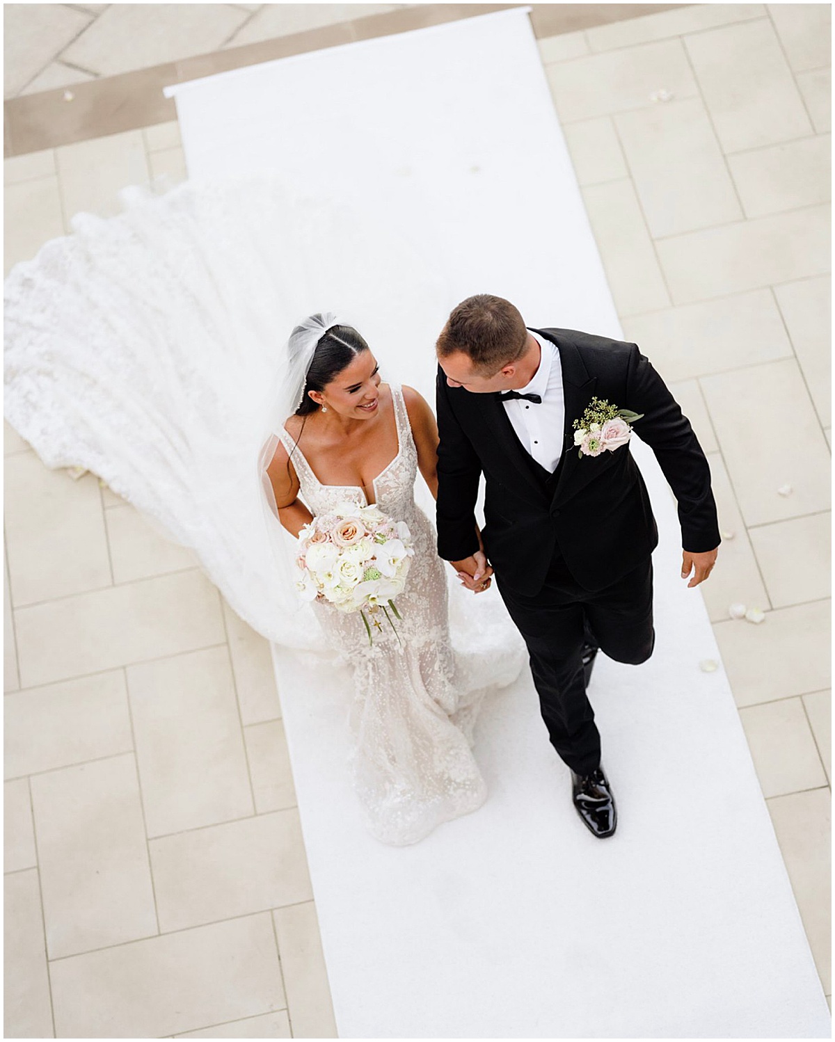 Bride and groom walking hand in hand during their Palm Beach wedding ceremony.